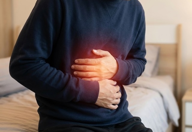 男子捂胃示意消化不良症狀，解析改善方法、吃什麼與穴位按摩。